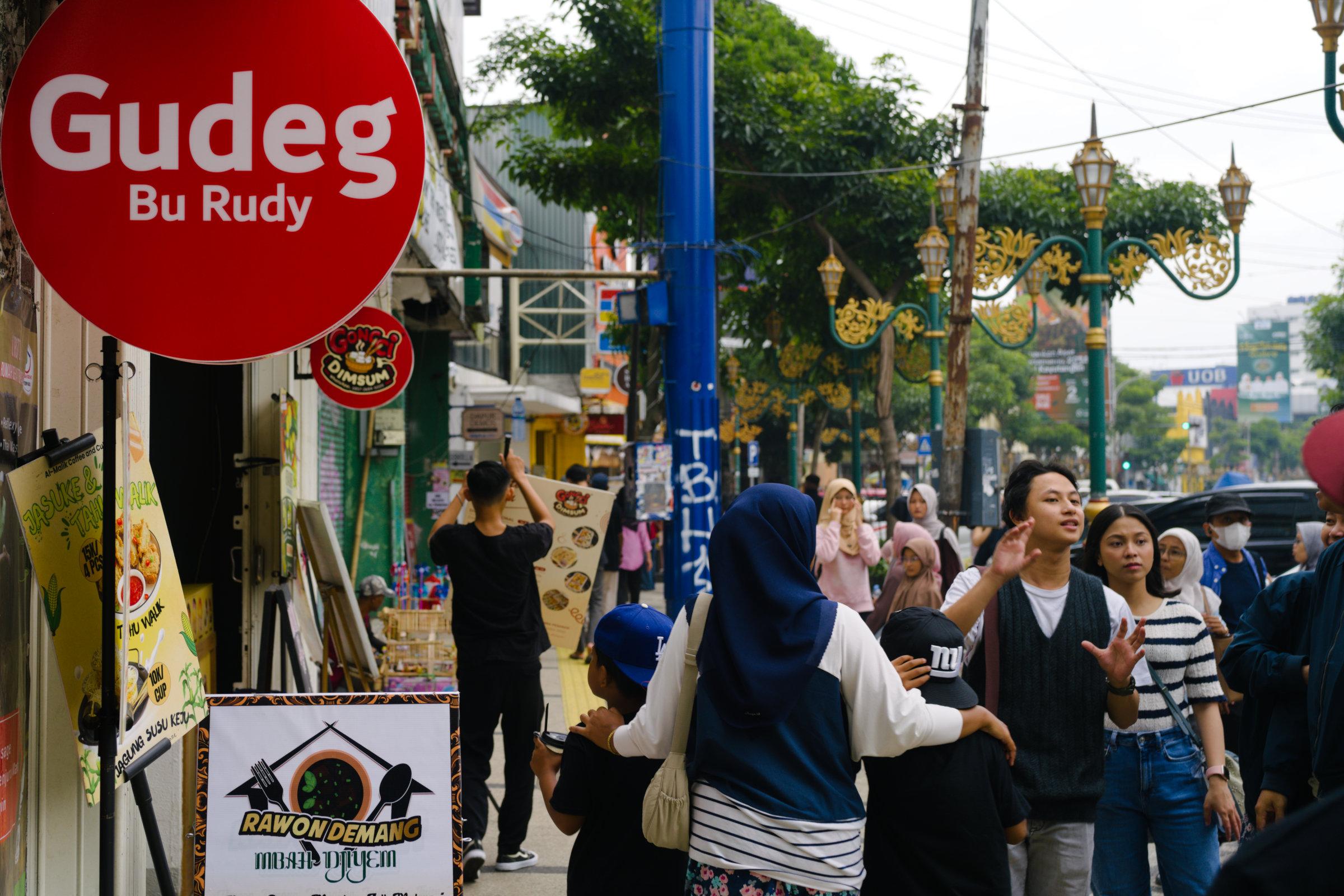 Crowded roadside scenery in front of an eatery.